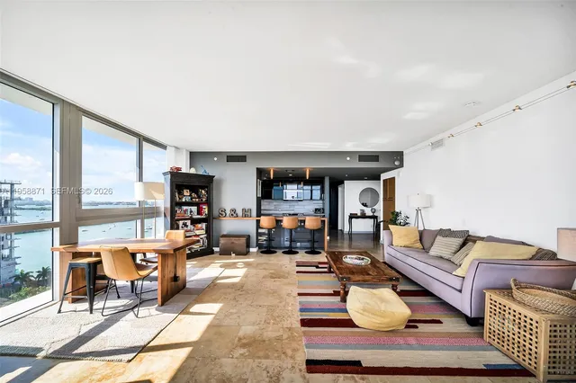 a living room with furniture and a floor to ceiling window