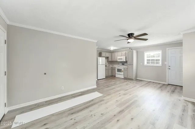 a view of empty room with wooden floor and window