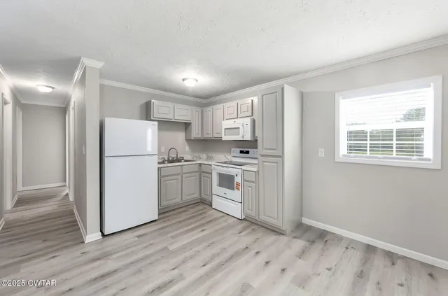 a kitchen with white cabinets and white appliances