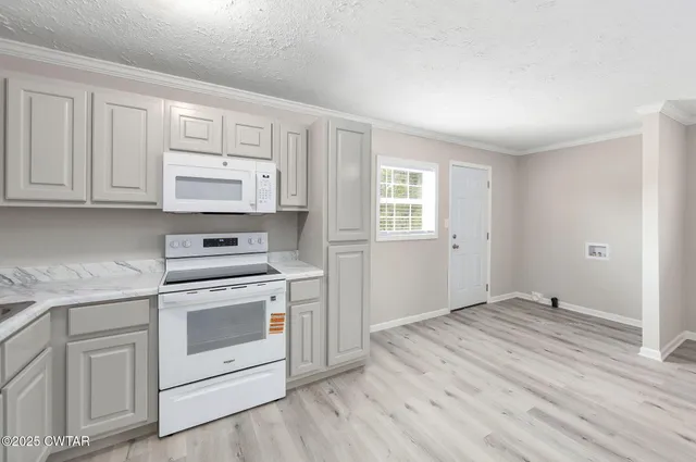 a kitchen with white cabinets and white appliances