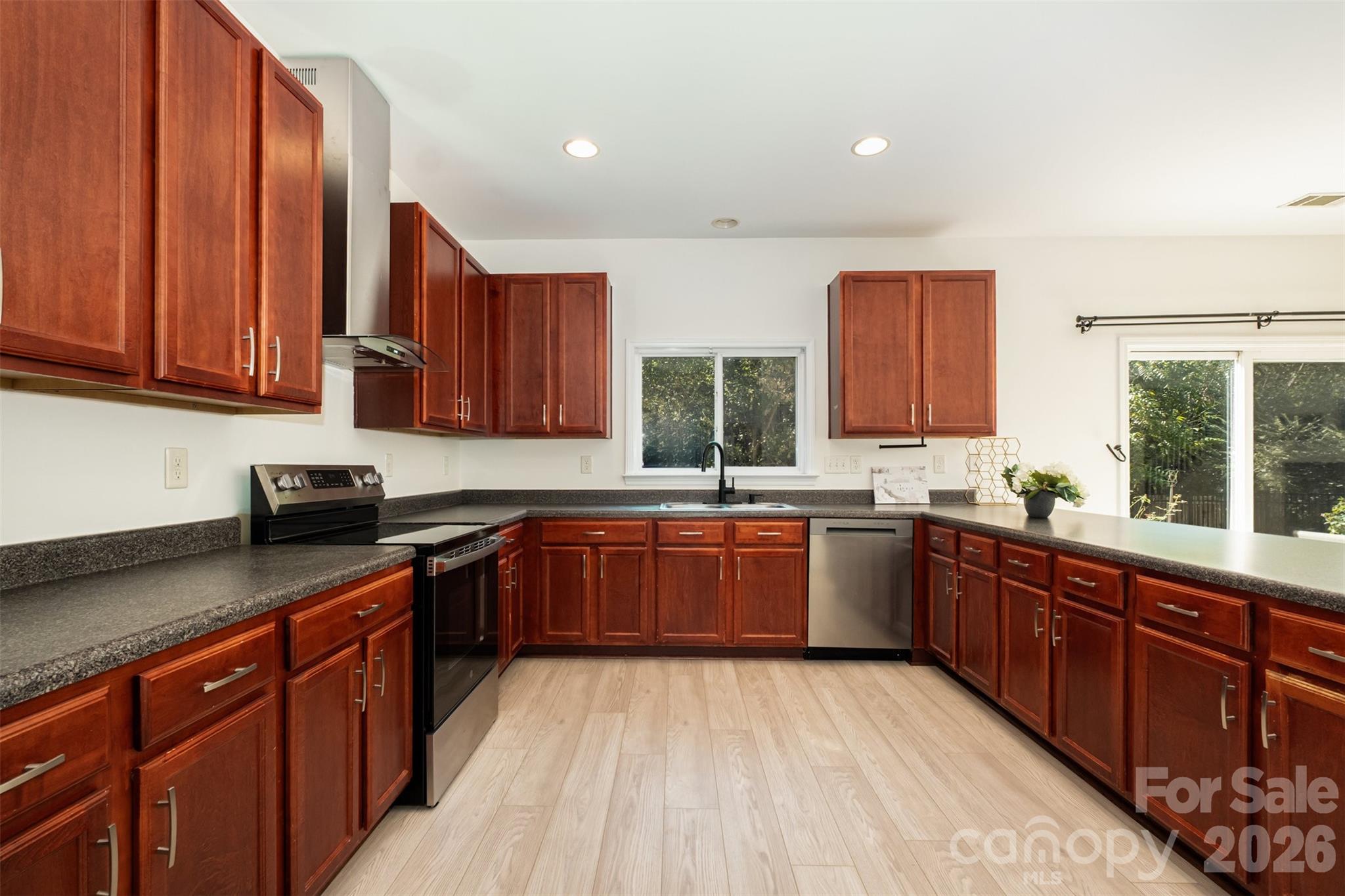 9213 Seamill Road Charlotte, NC 28278 - Photo 14 of 33 a kitchen with stainless steel appliances granite countertop wooden cabinets a sink and dishwasher a stove top oven with wooden floor