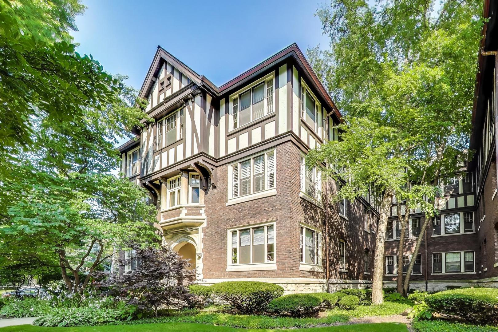 a front view of a residential apartment building with a yard and plants