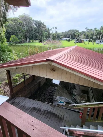 a view of a roof deck with table and chairs a barbeque with wooden fence