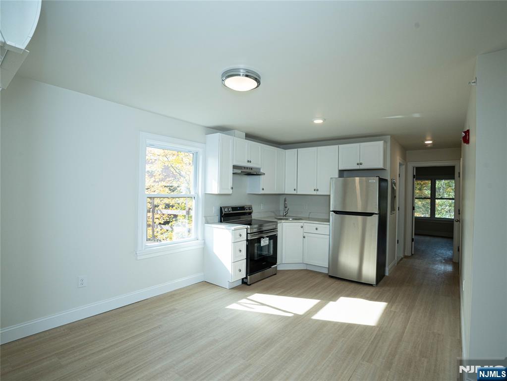 a kitchen with a refrigerator and a stove top oven