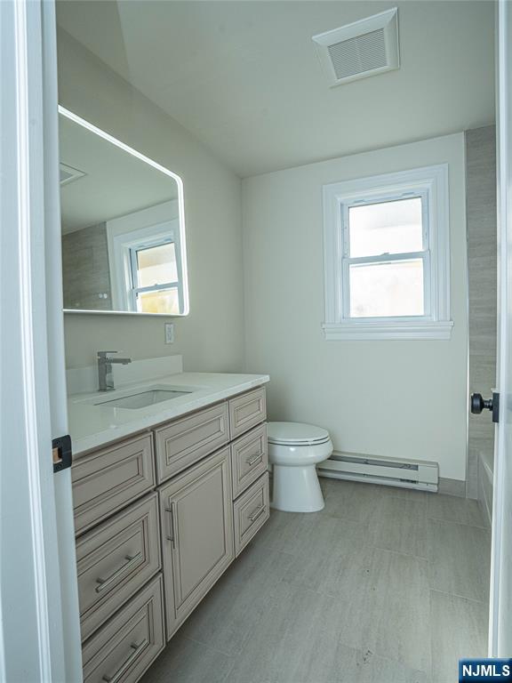 490 Broad Avenue, Unit 6 Leonia, NJ 07605 - Photo 6 of 8 a bathroom with a granite countertop toilet a sink and mirror
