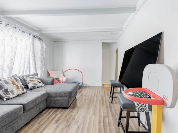 a living room with furniture a rug and a mirror