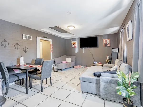 a living room with furniture a flat screen tv and a large window