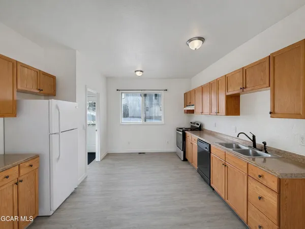 a kitchen with stainless steel appliances a refrigerator sink and white cabinets