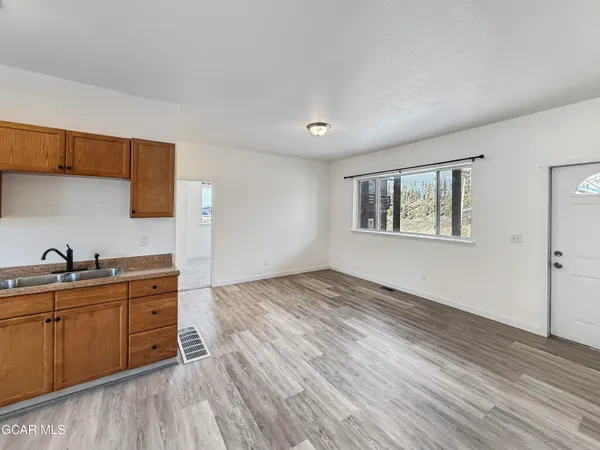 a view of a kitchen with sink cabinets and wooden floor