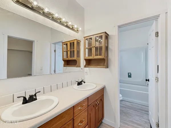 a bathroom with double vanity sinks a vanity and a mirror