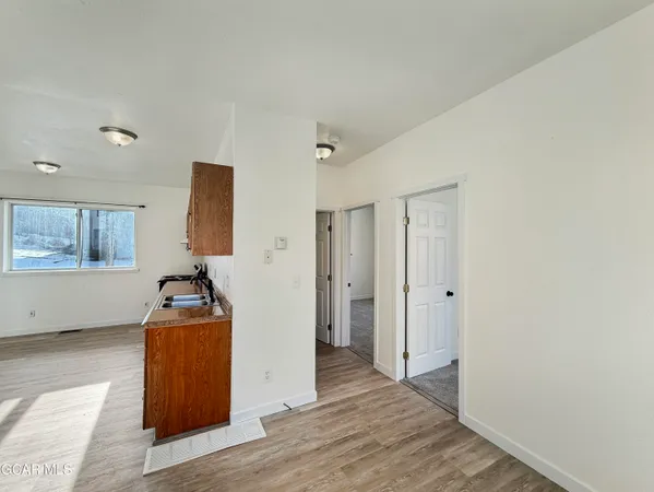 a view of a room with wooden floor cabinet and mirror