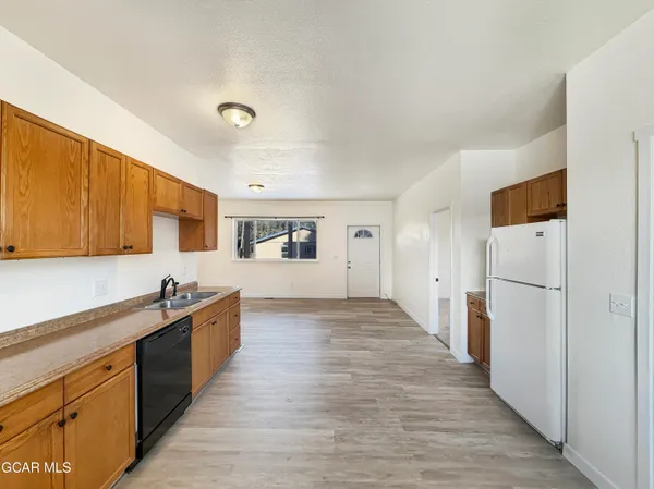 a large white kitchen with wooden floor