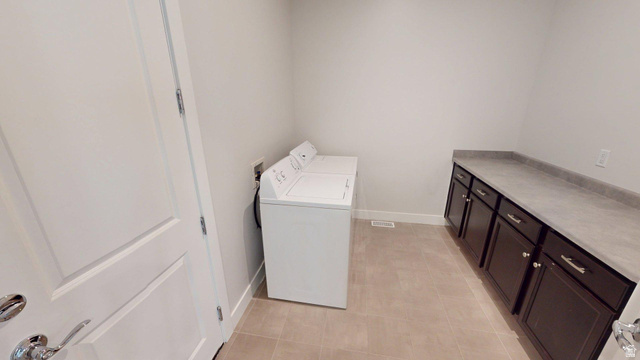 5502 North Valley View Road Lehi, UT 84048 - Photo 16 of 33 Laundry room featuring a full-size washer and dryer, extensive countertop space, and dark wood-finish cabinetry with silver hardware