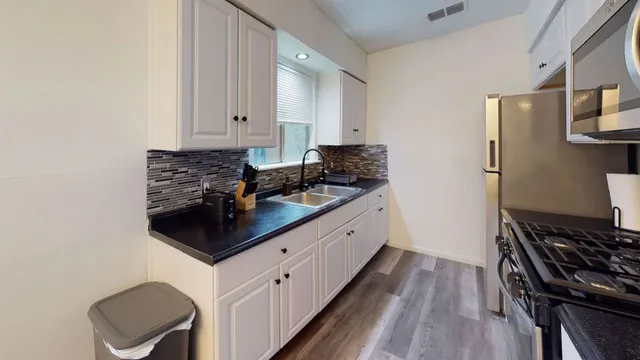 a kitchen with stainless steel appliances granite countertop a stove and a refrigerator
