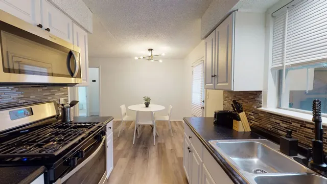 a kitchen with a stove a sink and a microwave