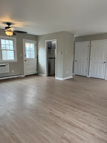 an empty room with wooden floor and windows