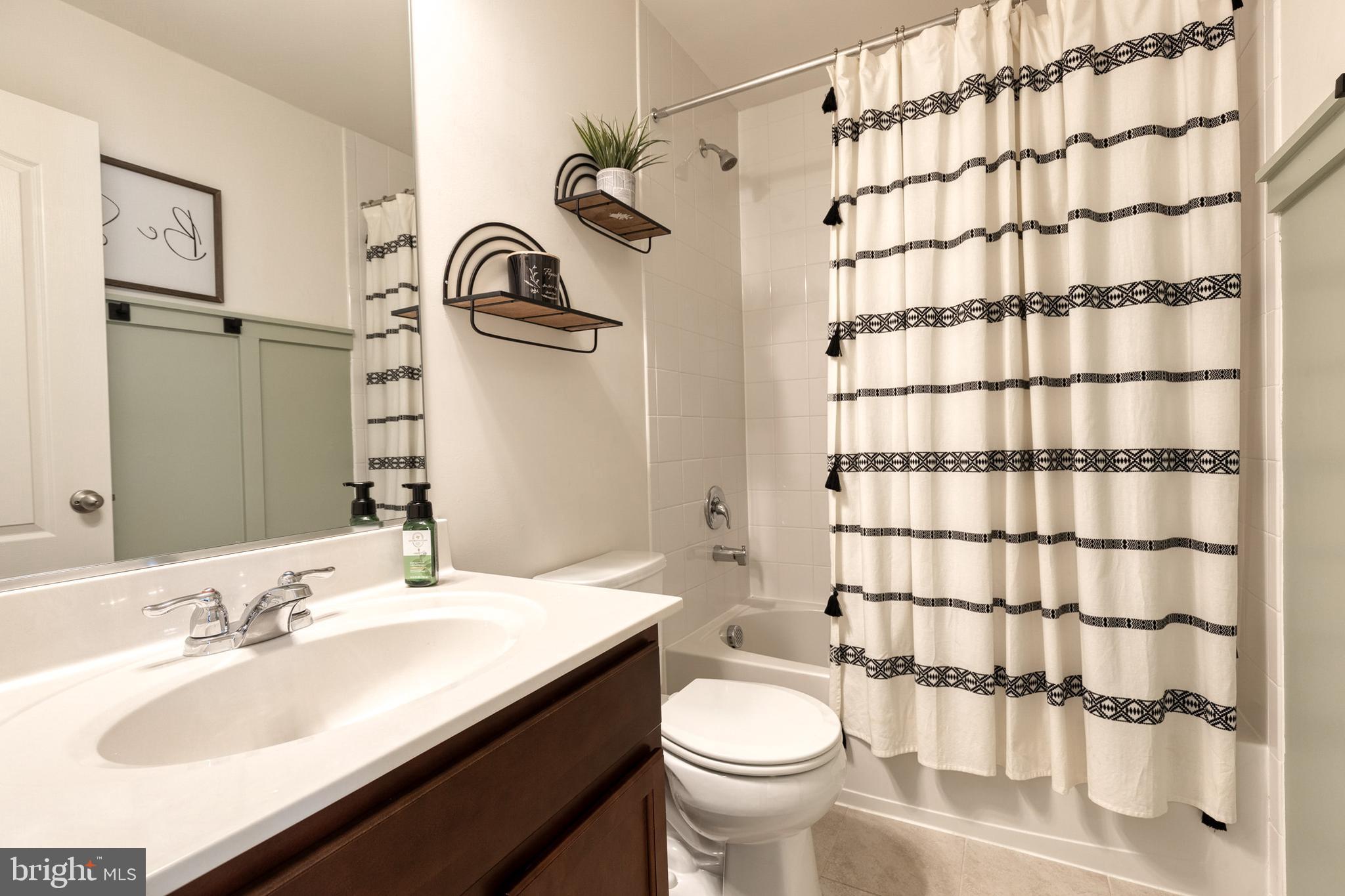 906 Sandy Run Road Baltimore, MD 21220 - Photo 23 of 31 a bathroom with a sink a toilet and shower curtain