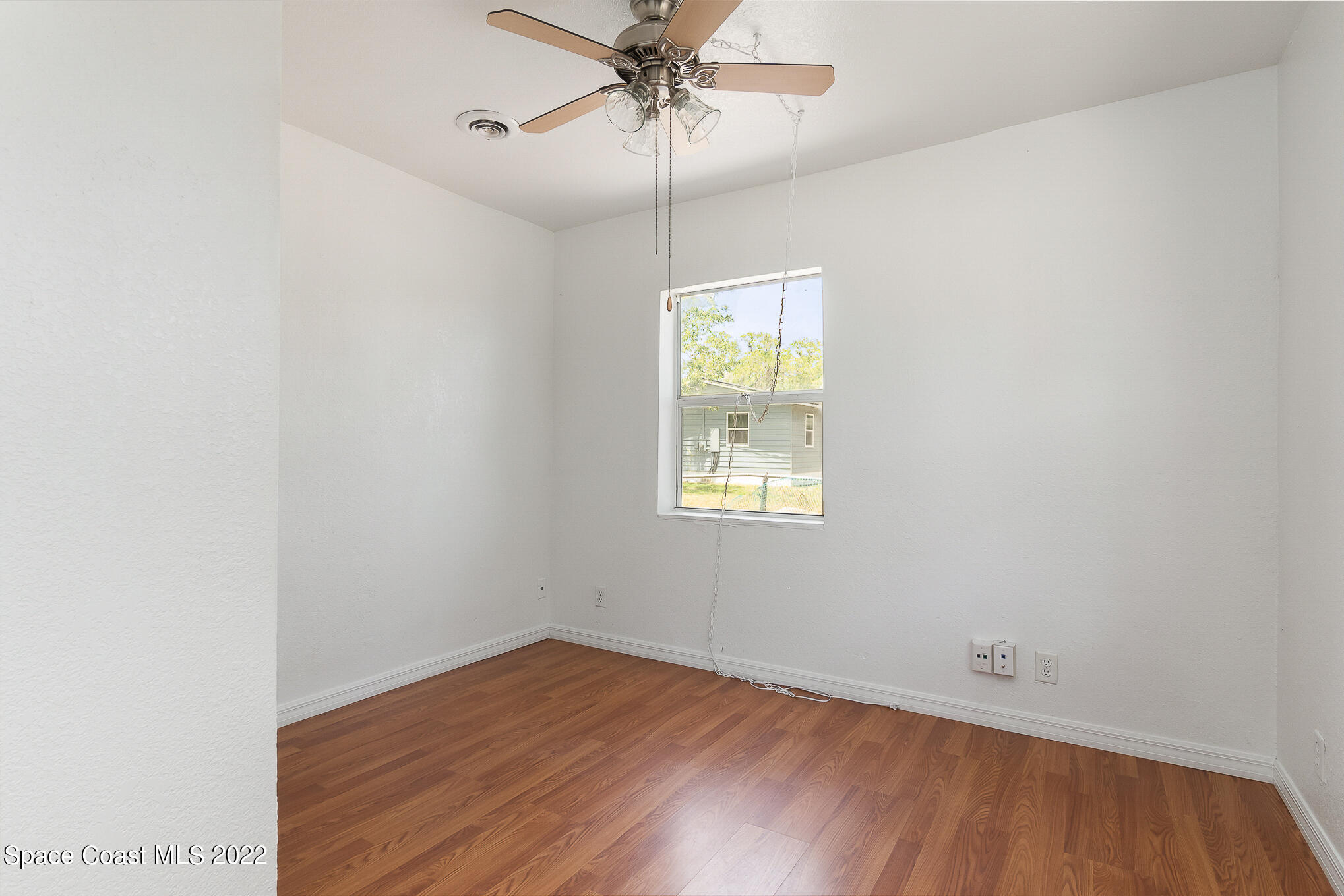 150 Capron Road Cocoa, FL 32927 - Photo 15 of 20 an empty room with a window and wooden floor