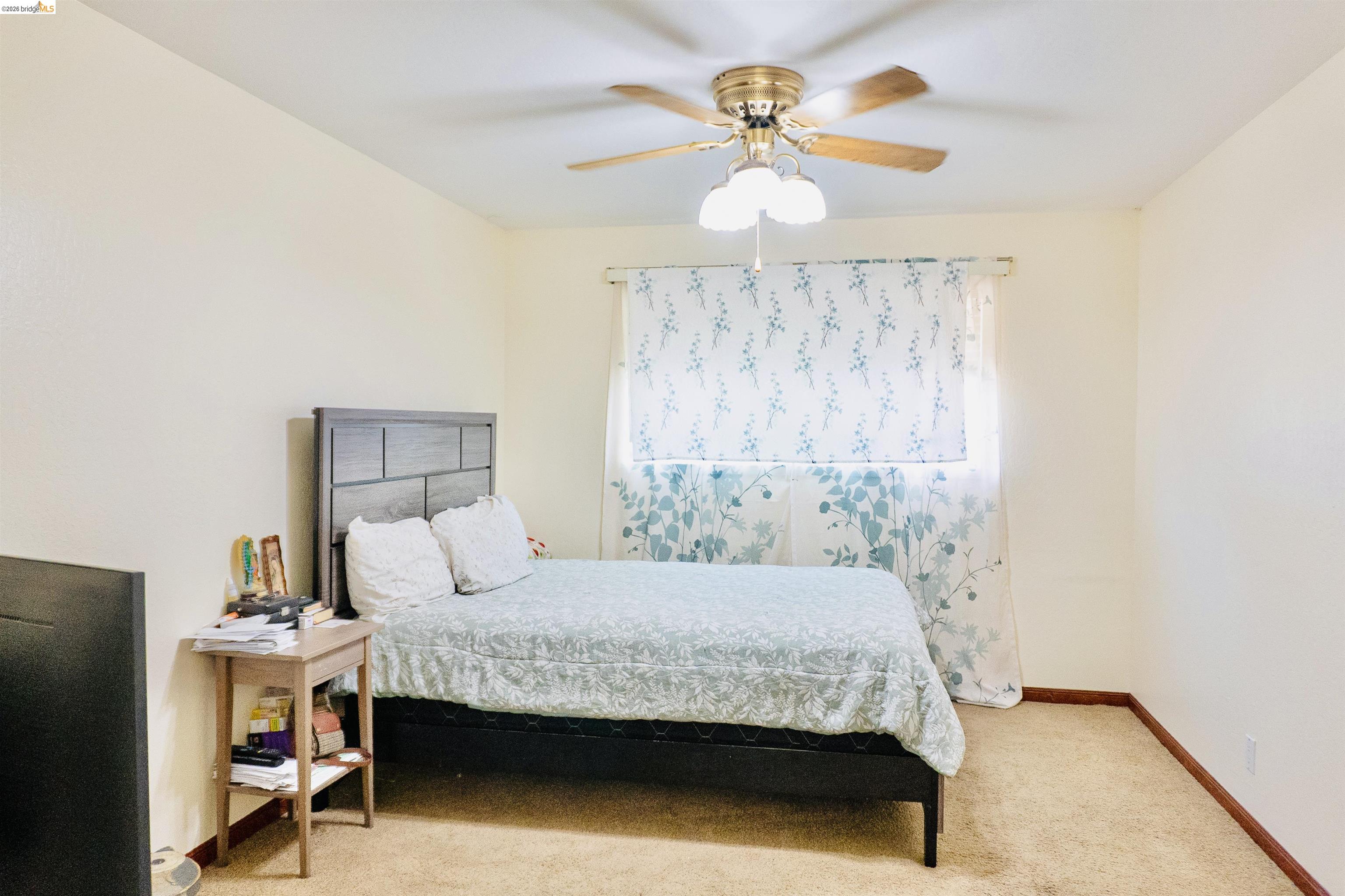 3513 Rio Grande Drive Antioch, CA 94509 - Photo 15 of 22 Carpeted room with a ceiling fan light fixture, light-colored walls, and a window with curtains