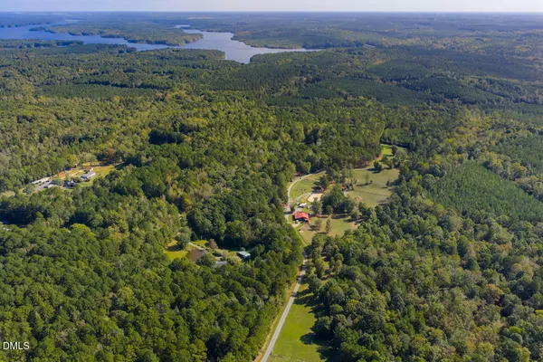 an aerial view of residential house with outdoor space and trees all around