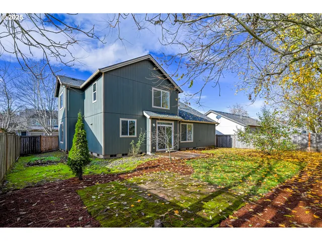 an aerial view of residential houses with outdoor space and trees