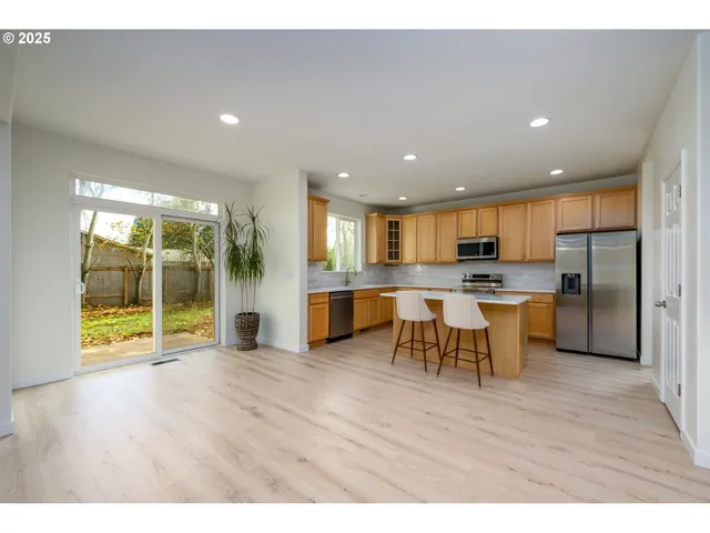 a open kitchen with cabinets wooden floor and a fireplace