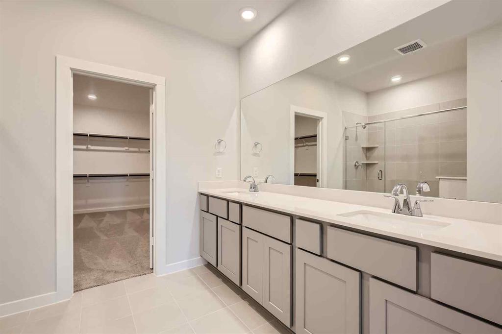 736 Vineyard Way Forney, TX 75126 - Photo 12 of 40 a bathroom with a double vanity sink and mirror