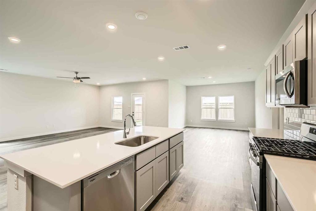 736 Vineyard Way Forney, TX 75126 - Photo 6 of 40 a large kitchen with kitchen island a sink stainless steel appliances and cabinets