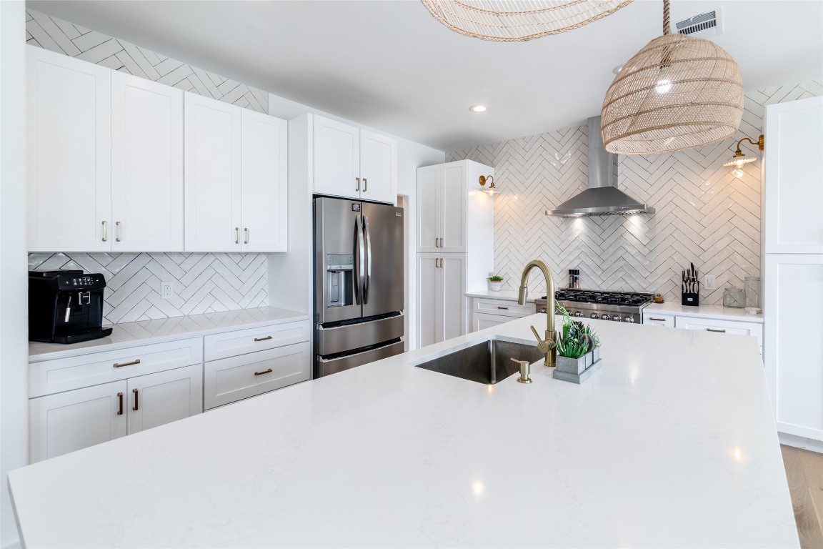 31 West Valley Spring Road Wimberley, TX 78676 - Photo 12 of 38 a kitchen with stainless steel appliances a stove a refrigerator and white cabinets
