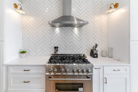 a kitchen with a stove and white cabinets