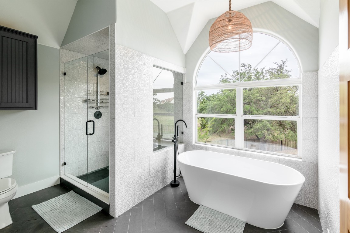 31 West Valley Spring Road Wimberley, TX 78676 - Photo 19 of 38 a bathroom with a bathtub and a chandelier