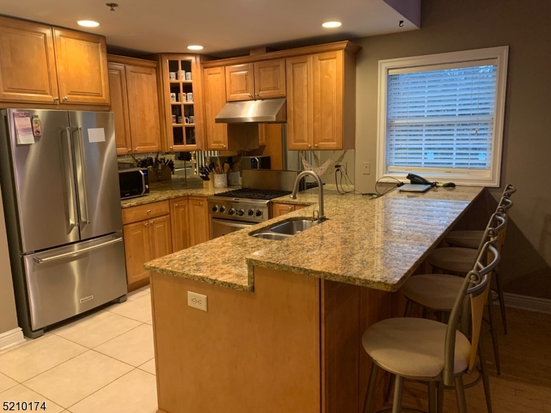 a kitchen with refrigerator and chairs