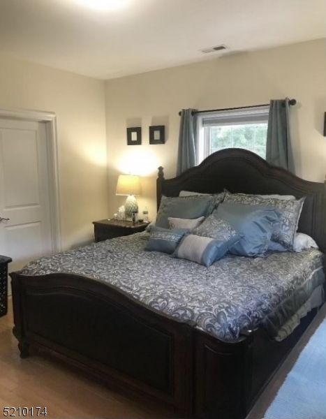 453 Springfield Avenue Berkeley Heights, NJ 07922 - Photo 7 of 13 a bedroom with a bed and a potted plant on dresser