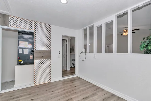 an empty room with windows and chandelier fan