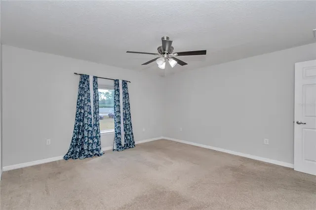 en empty room with windows and fan