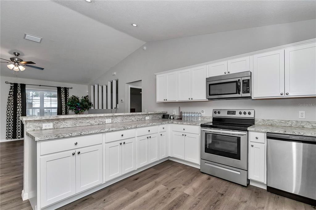 14 Maple Run Ocala, FL 34472 - Photo 5 of 43 a kitchen with granite countertop white cabinets and stainless steel appliances