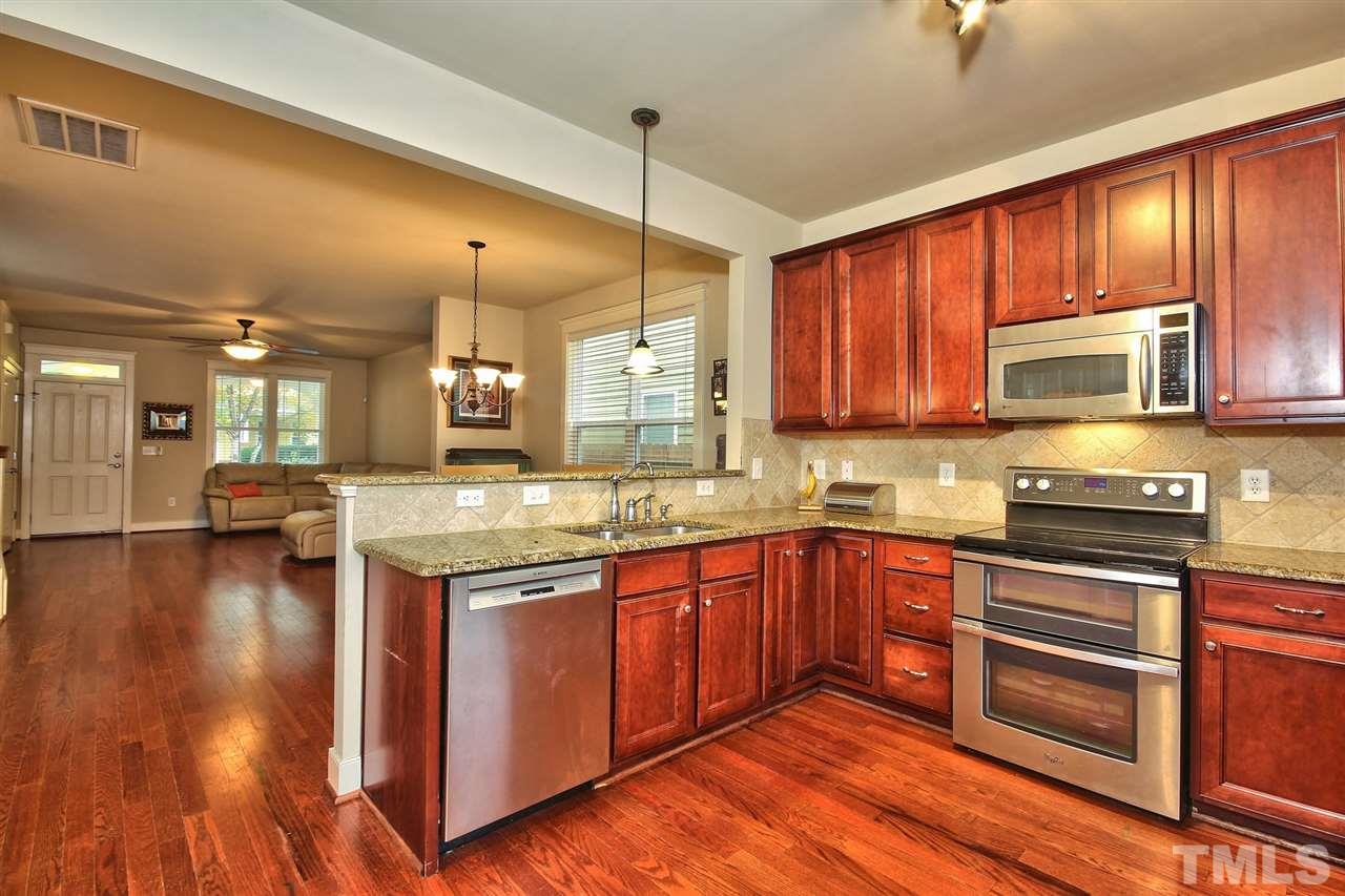 4523 All Points View Way Raleigh, NC 27614 - Photo 9 of 21 a kitchen with stainless steel appliances granite countertop wooden cabinets a stove a sink and dishwasher with wooden floor