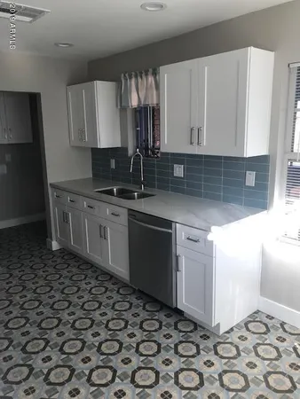 a kitchen with a sink a stove and cabinets