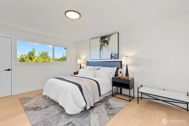 a bedroom with a bed and painting on the wall