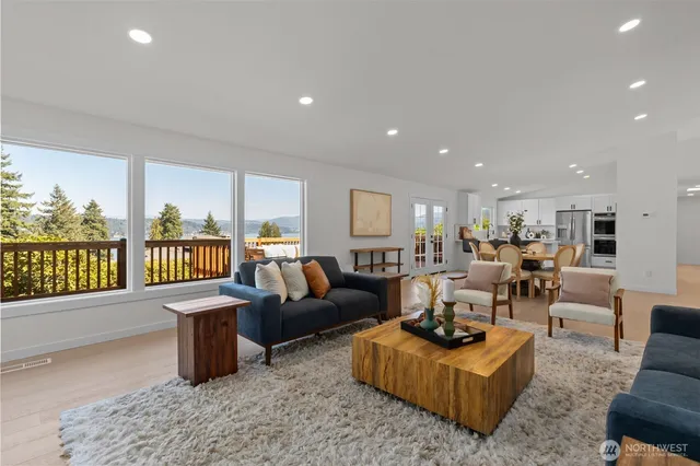 a living room with furniture wooden floor and a large window