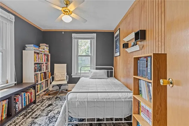 a bedroom with a bed bookshelf and a window