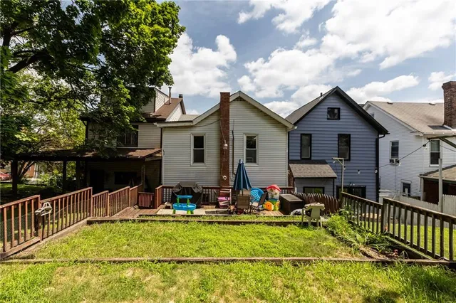 a view of a house with wooden deck and furniture