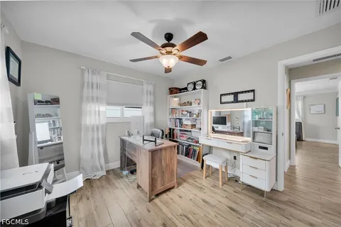 a view of a workspace with furniture and wooden floor