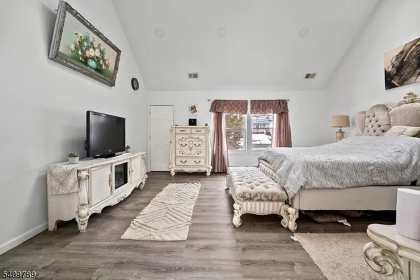 a bedroom with furniture and a flat screen tv