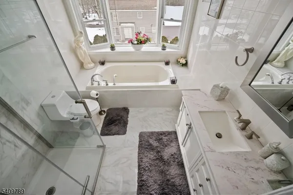 a bathroom with a sink and mirror with bathtub