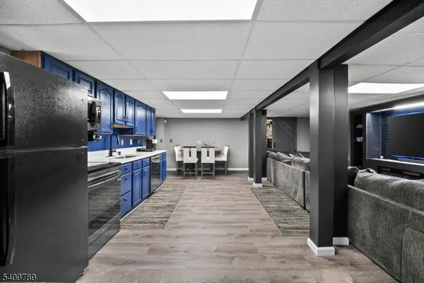 a large kitchen with kitchen island a large counter top space a sink stainless steel appliances and cabinets
