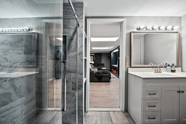 a en suite bathroom with a sink a mirror and shower