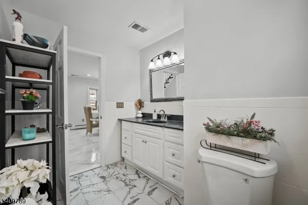 a spacious bathroom with a toilet a sink and mirror