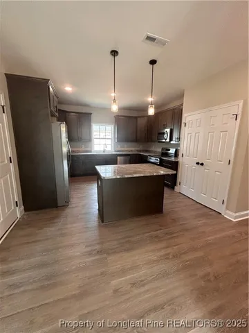 a kitchen with stainless steel appliances granite countertop a sink a stove and a refrigerator