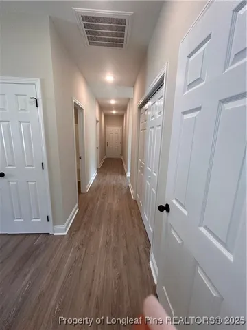 a view of a hallway with wooden floor and staircase